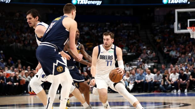 Mar 11, 2020; Dallas, Texas, USA; Dallas Mavericks guard Luka Doncic (77) dribbles as Denver Nuggets center Nikola Jokic (15) defends during the first quarter at American Airlines Center. Mandatory Credit: Kevin Jairaj-USA TODAY Sports
